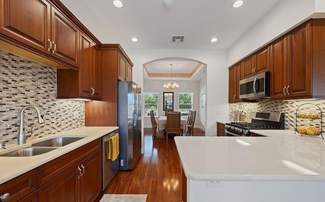 kitchen with decorative backsplash, stainless steel appliances, sink, an inviting chandelier, and dark hardwood / wood-style floors