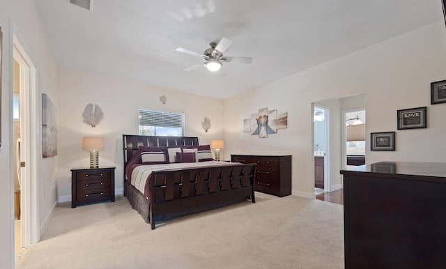 bedroom with ceiling fan, light carpet, and connected bathroom