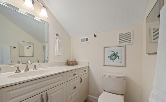 bathroom featuring vanity, toilet, and vaulted ceiling