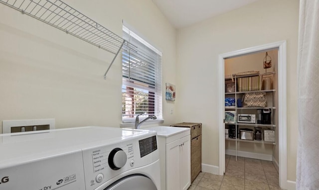 clothes washing area with cabinets, independent washer and dryer, light tile patterned flooring, and sink