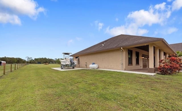 back of property with a lawn and a patio