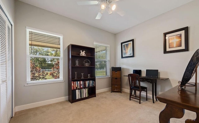 office with a healthy amount of sunlight, ceiling fan, and light colored carpet