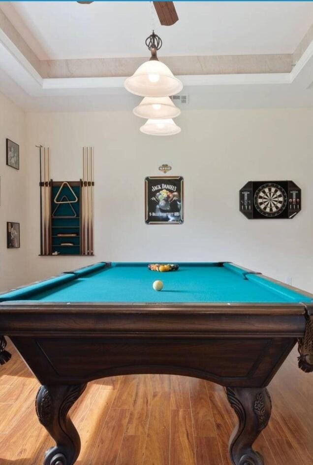 recreation room featuring wood-type flooring, a raised ceiling, and pool table