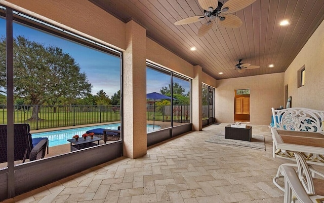 sunroom / solarium with ceiling fan and wooden ceiling