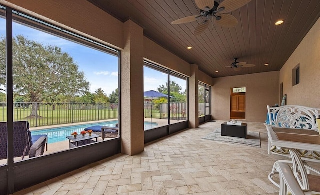 sunroom / solarium with ceiling fan and wood ceiling