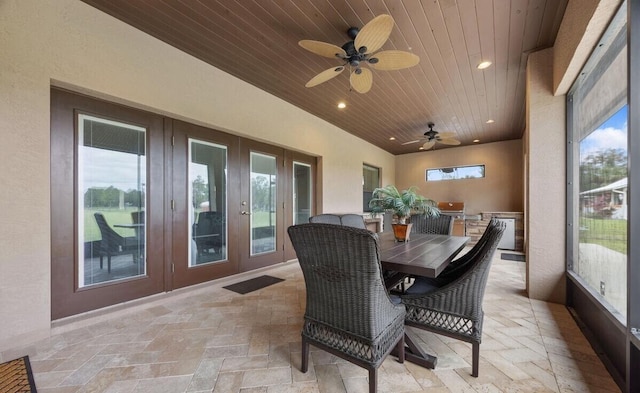 sunroom featuring ceiling fan and wooden ceiling