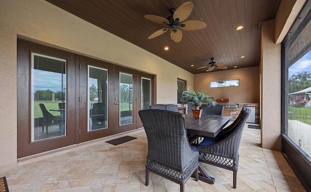 sunroom featuring ceiling fan and wood ceiling