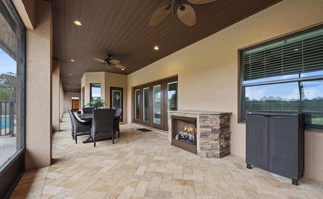 view of patio / terrace featuring an outdoor stone fireplace and ceiling fan