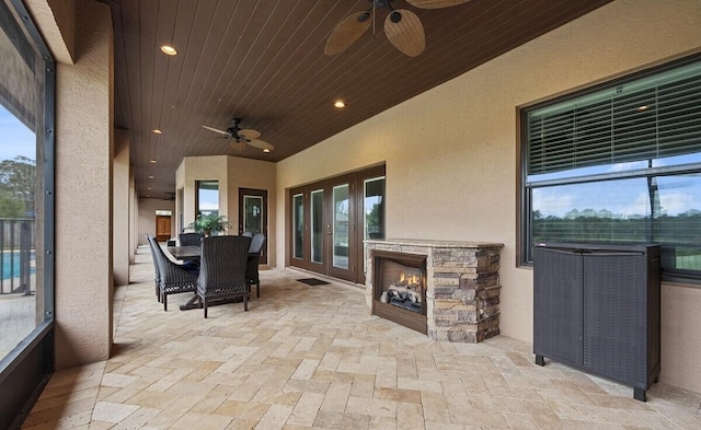 view of patio / terrace with an outdoor stone fireplace and ceiling fan