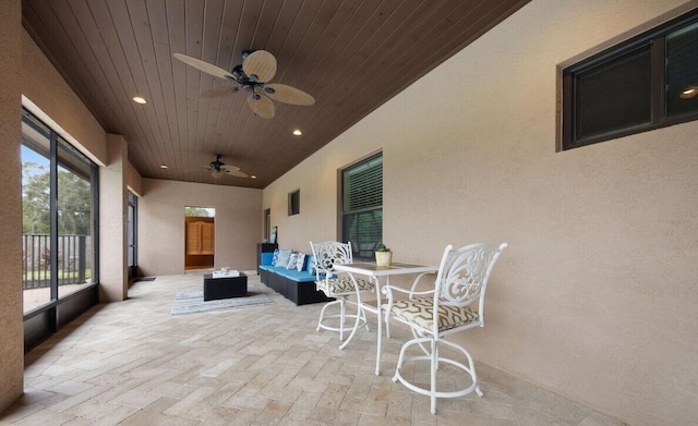 sunroom featuring ceiling fan, wood ceiling, and vaulted ceiling