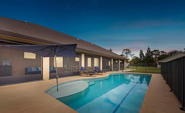 pool at dusk with a patio