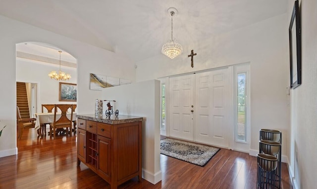 entrance foyer with dark hardwood / wood-style floors and an inviting chandelier