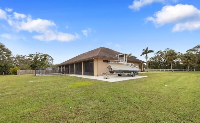 rear view of house featuring a sunroom and a lawn