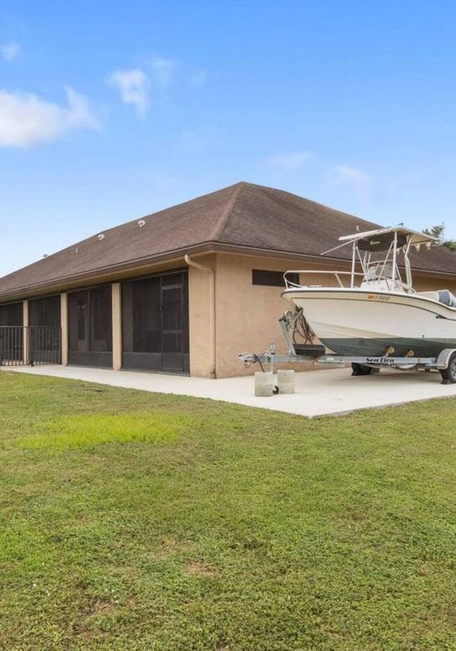 rear view of property featuring a sunroom and a yard