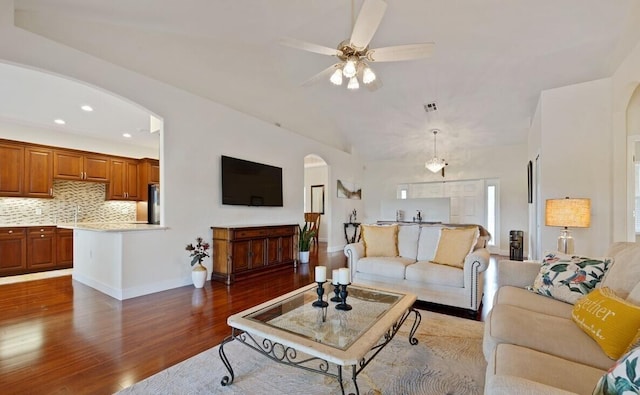 living room with ceiling fan, sink, and dark wood-type flooring