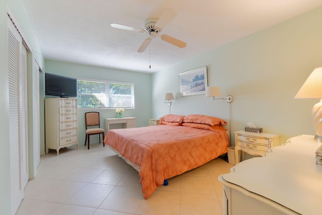 tiled bedroom featuring ceiling fan and a closet