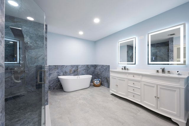 bathroom with vanity, independent shower and bath, and tile walls