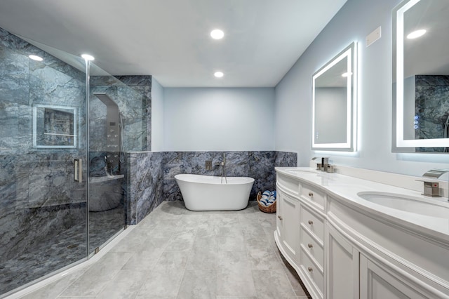 bathroom featuring vanity, tile walls, and shower with separate bathtub