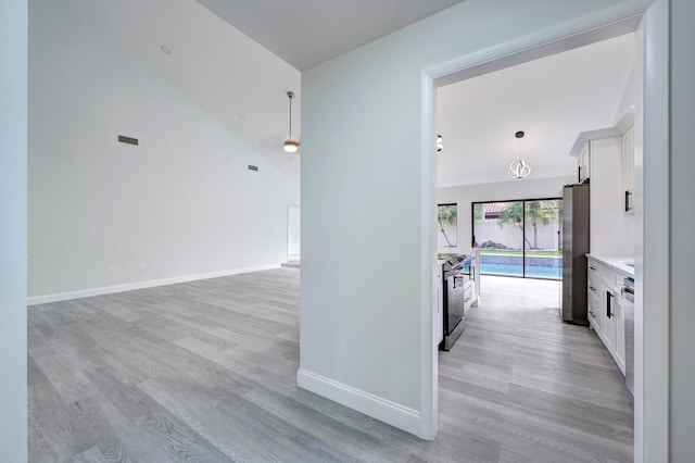 hallway featuring lofted ceiling and light wood-type flooring