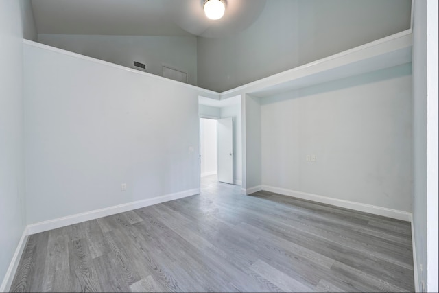 empty room with hardwood / wood-style floors and high vaulted ceiling