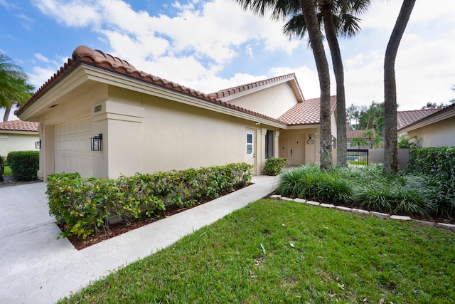 view of side of home featuring a lawn and a garage