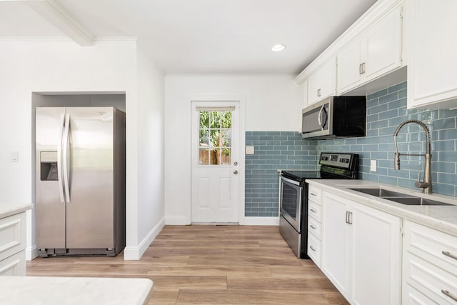 kitchen with sink, appliances with stainless steel finishes, crown molding, white cabinets, and light wood-type flooring