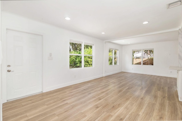 unfurnished room featuring light hardwood / wood-style floors and ornamental molding