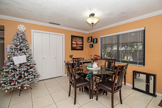 tiled dining area featuring crown molding