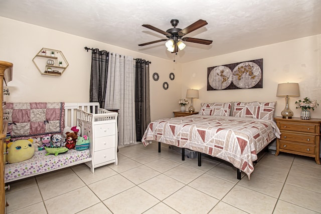 bedroom featuring tile patterned flooring, a textured ceiling, and ceiling fan