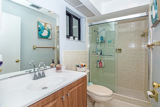 bathroom featuring vanity, toilet, walk in shower, and tile walls