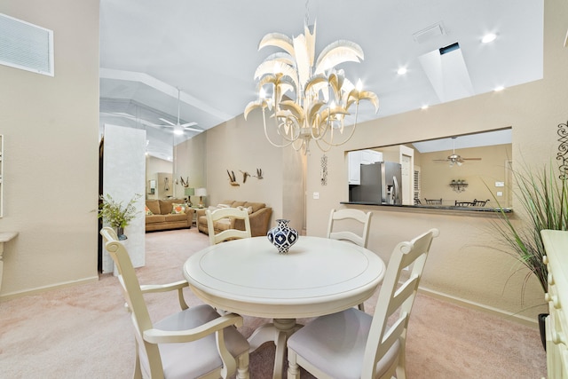 dining area featuring ceiling fan with notable chandelier, light colored carpet, and lofted ceiling