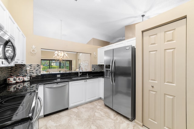 kitchen with white cabinets, decorative backsplash, stainless steel appliances, and hanging light fixtures