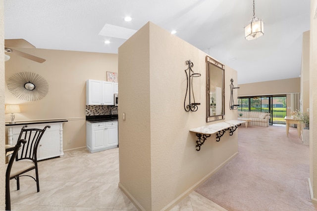 hall with light colored carpet and lofted ceiling