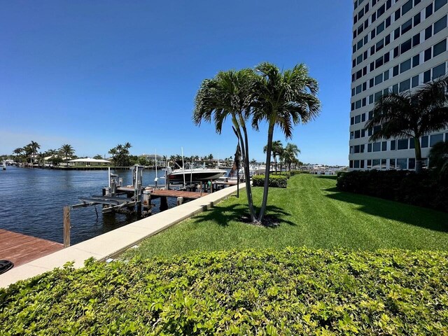 dock area with a water view and a lawn