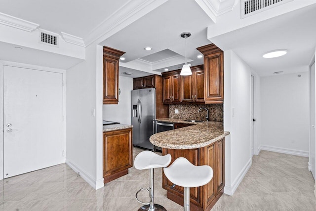 kitchen with appliances with stainless steel finishes, ornamental molding, sink, dark stone countertops, and hanging light fixtures