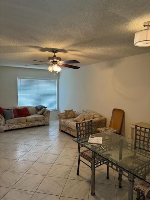 dining area with a textured ceiling, ceiling fan, and light tile patterned floors