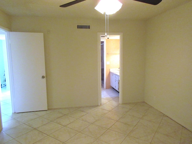 tiled spare room with ceiling fan