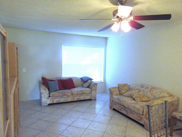 tiled living room with ceiling fan and a textured ceiling