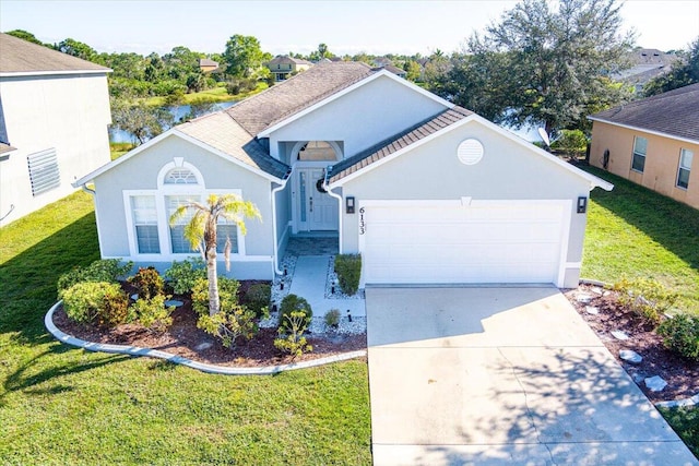 view of property with a garage and a front lawn