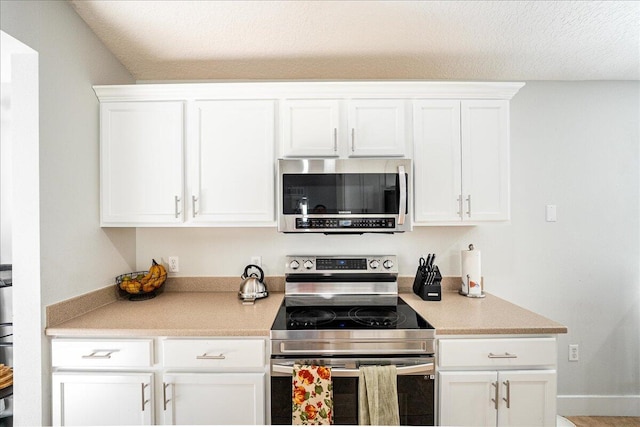 kitchen featuring white cabinets, appliances with stainless steel finishes, and a textured ceiling