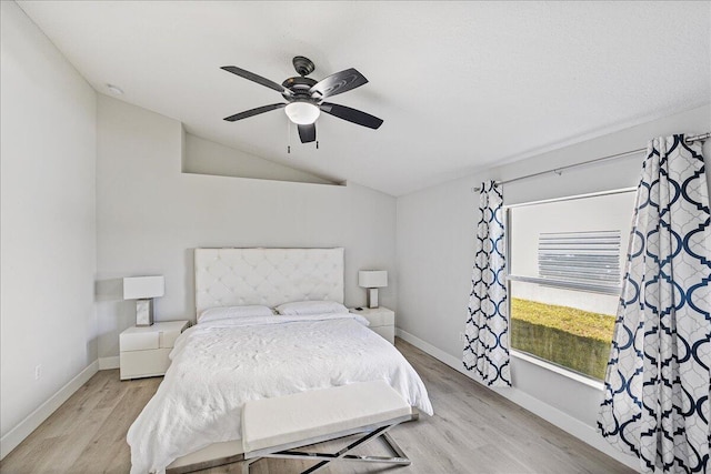 bedroom with ceiling fan, light hardwood / wood-style flooring, and lofted ceiling