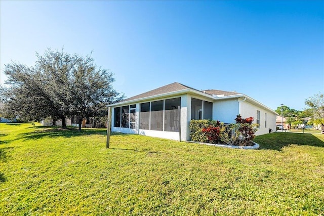 rear view of property featuring a lawn and a sunroom