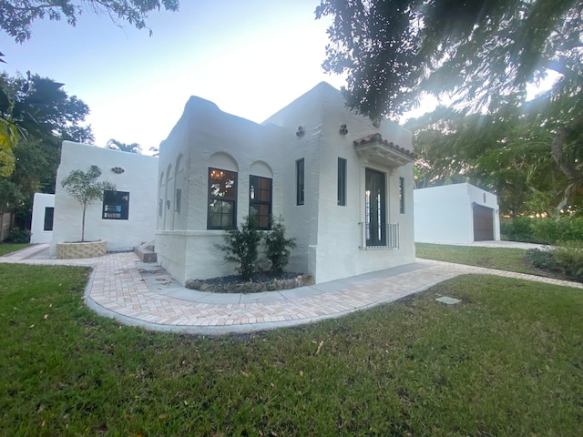 view of home's exterior with a garage and a lawn