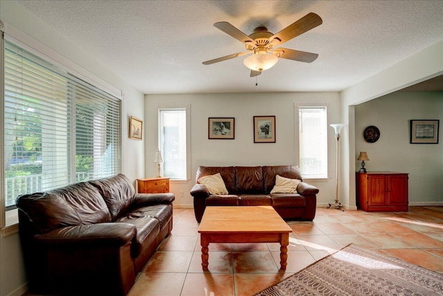 tiled living room featuring a textured ceiling and ceiling fan