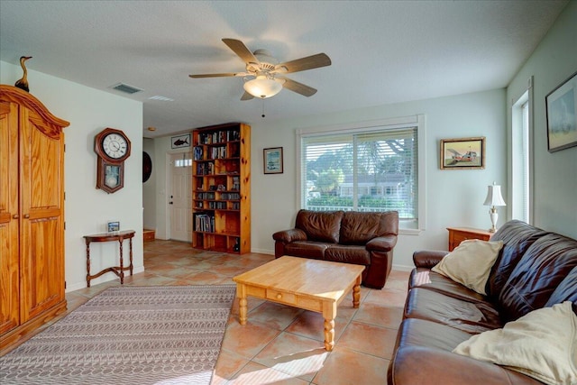 tiled living room featuring ceiling fan and a textured ceiling