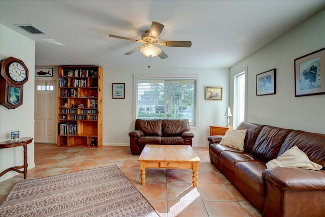 tiled living room featuring ceiling fan and a textured ceiling