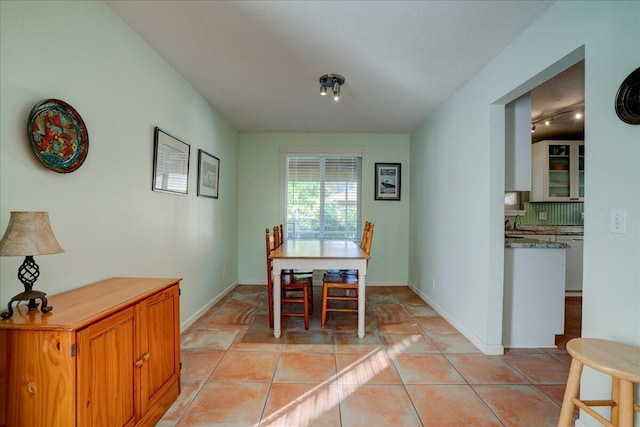 dining area featuring light tile patterned floors and a textured ceiling