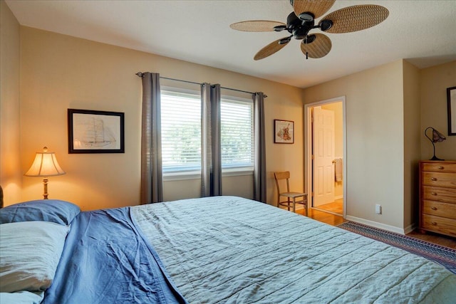 bedroom featuring ensuite bath, ceiling fan, and hardwood / wood-style flooring