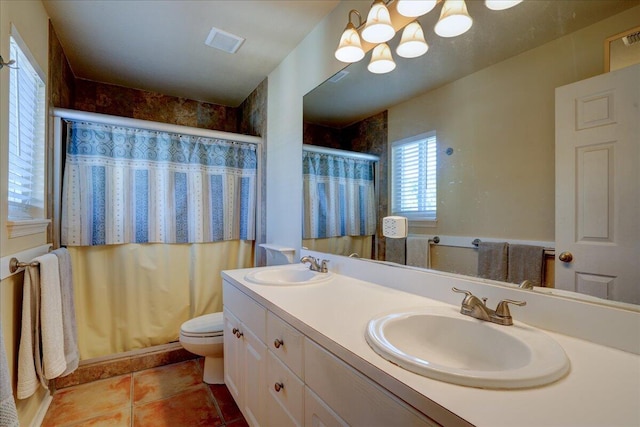 bathroom featuring tile patterned flooring, vanity, toilet, and walk in shower