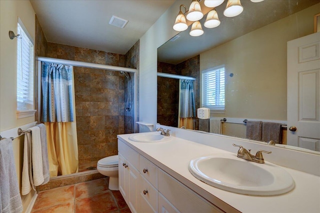 bathroom with toilet, vanity, tiled shower, and tile patterned floors